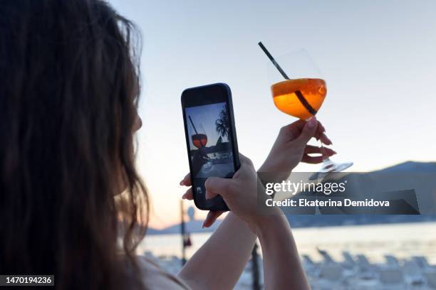 woman taking photo of cocktail on beach - prisoner phone stock pictures, royalty-free photos & images