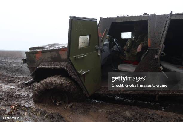 Ukrainian military member sits in a pickup truck that bogged down in the mud on February 26, 2023 in Donetsk Oblast, Ukraine. After the withdrawal of...