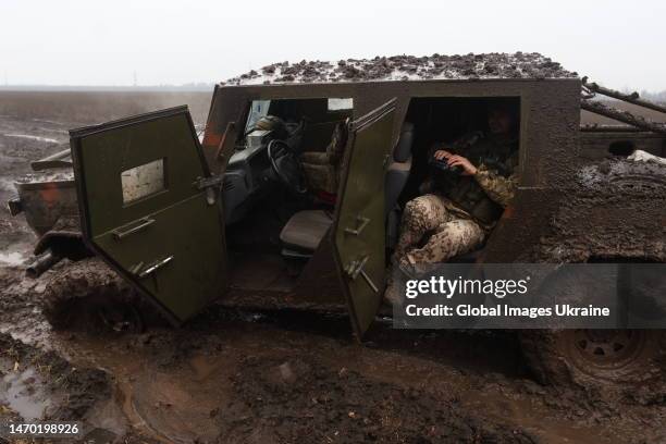 Ukrainian military member sits in a pickup truck that bogged down in the mud on February 26, 2023 in Donetsk Oblast, Ukraine. After the withdrawal of...