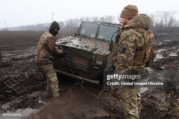 Ukrainian military members attach a wire rope to a pickup truck... News ...
