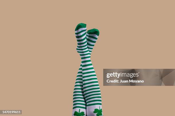 upside-down wearing stockings patterned with a shamrock - witte klaver stockfoto's en -beelden