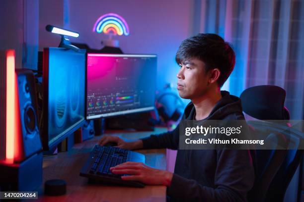 asian male video editor working with footage on computer. - video editing foto e immagini stock