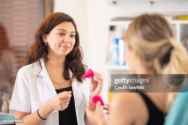 female gynecologist doctor and patient are talking about menstrual cup - period cup stockfoto's en -beelden