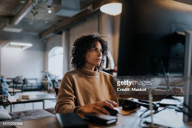 female programmer concentrating while working on computer at desk in office - developer stock pictures, royalty-free photos & images