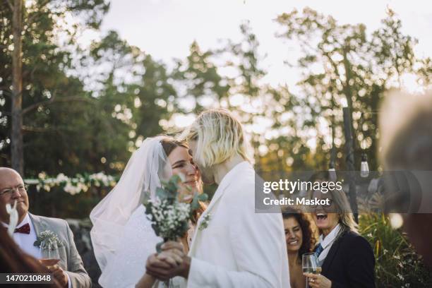 happy bride and groom dancing together amidst guests during wedding ceremony - arabic wedding stock pictures, royalty-free photos & images