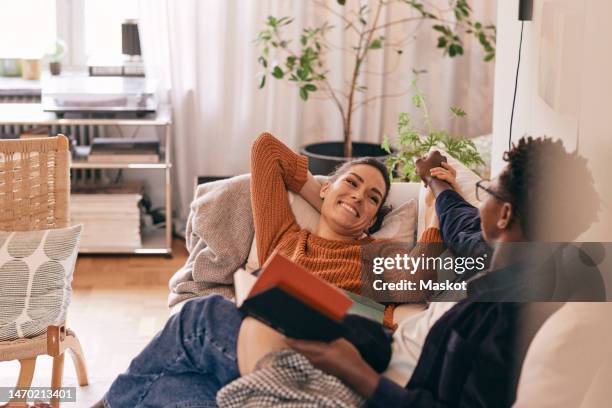 happy couple spending leisure time on sofa at home - love books stock pictures, royalty-free photos & images