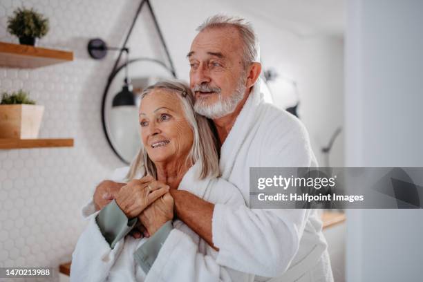 senior couple in the bathroom, having morning hygiene routine. - senioren in bad stock-fotos und bilder