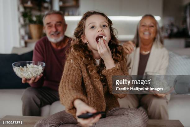 grandparents watching tv with their granddaughter. - familia viendo la television fotografías e imágenes de stock