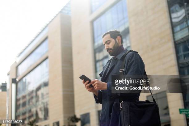 businessman texting - business men walking stock pictures, royalty-free photos & images