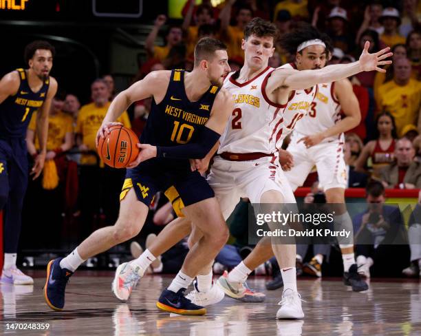 Erik Stevenson of the West Virginia Mountaineers passes the ball as Caleb Grill of the Iowa State Cyclones defends in the first half of play at...