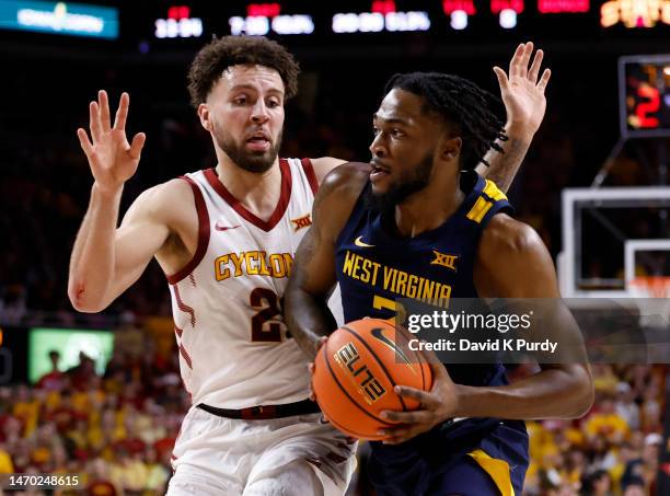 Kobe Johnson of the West Virginia Mountaineers drives the ball as Gabe Kalscheur of the Iowa State Cyclones defends in the second half of play at...