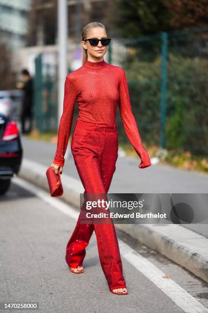 Caroline Daur wears black sunglasses, a red glitter / embroidered rhinestones high neck / long sleeves t-shirt, red red with embroidered rhinestones...