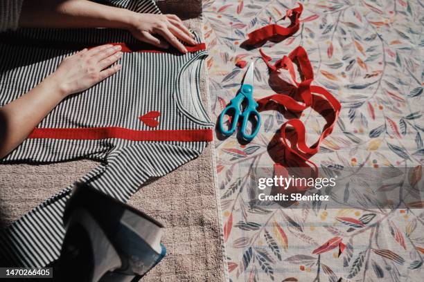 unrecognizable fashion designer cutting fabric in her design workshop - schnittmuster stock-fotos und bilder