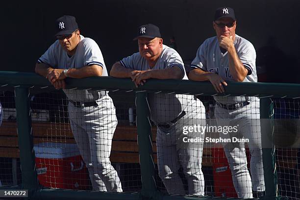 Manager Joe Torre and coaches Don Zimmer and Mel Stottlemyre of the New York Yankees look on after the Anaheim Angels took a 9-2 lead during game 4...