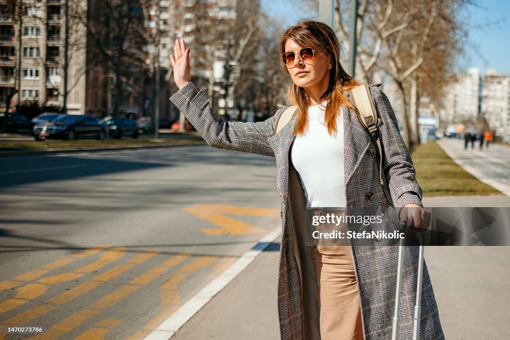 Woman stops a taxi