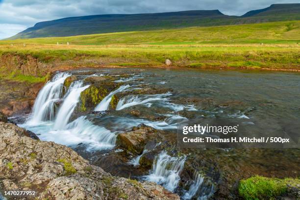 scenic view of waterfall against sky,northwestern,iceland - brook mitchell stock pictures, royalty-free photos & images