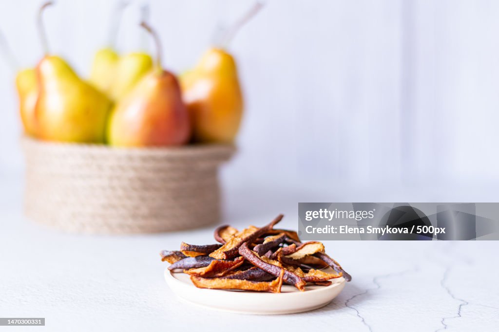 Dried pears on a light background next to a basket of fresh pears,Moscow,Russia