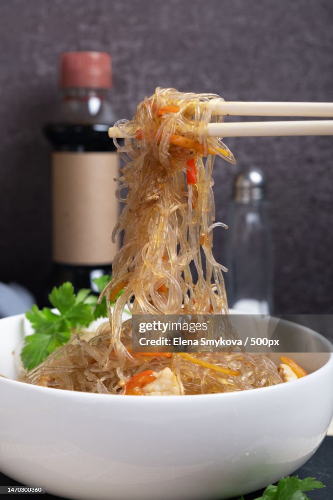 Chopsticks are taken out of the bowl funchosa,A dish of Asian cuisine,Moscow,Russia