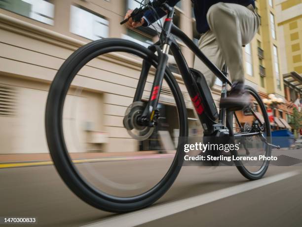 a professional man electric bicycle ebike commuting to work through the traffic of san diego, california, usa - elcykel bildbanksfoton och bilder