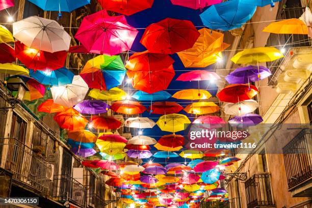 paraguas cubriendo una calle histórica en catania, sicilia, italia por la noche - catania sicily fotografías e imágenes de stock