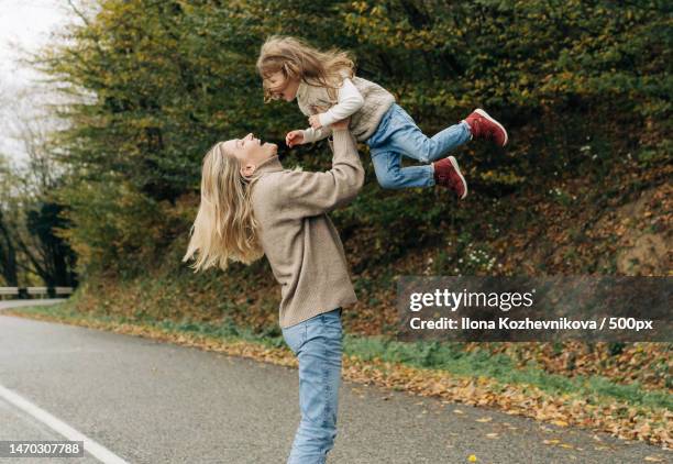 laughing mother throws up her little cheerful daughter in her arms,sochi,krasnodar krai,russia - sochi stock pictures, royalty-free photos & images