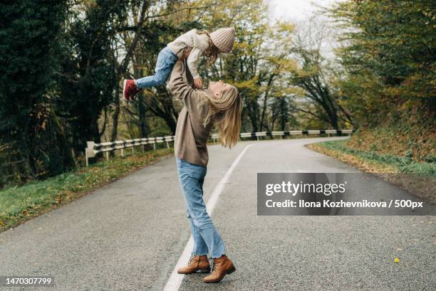 laughing mother throws up her little cheerful daughter in her arms,sochi,krasnodar krai,russia - sochi russia stock pictures, royalty-free photos & images