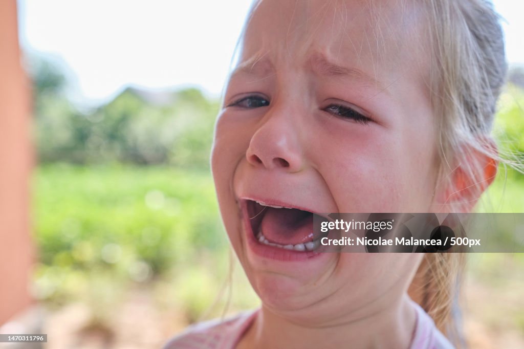 Little preschool Beautiful sad little girl crying she got hurt outdoor