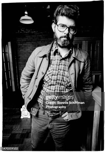 Filmmaker George Lucas poses with his hands in his pockets and R2-D2 in the background in Los Angeles in 1979.