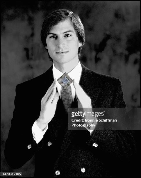 Tech entrepreneur Steve Jobs adjusts his square tie collar pin and smiles softly at camera in Los Angeles in 1986.