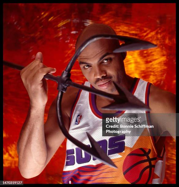 Basketball legend Charles Barkley holds a pitchfork in front of his face and wears a Phoenix Suns jersey in Los Angeles in 1993.
