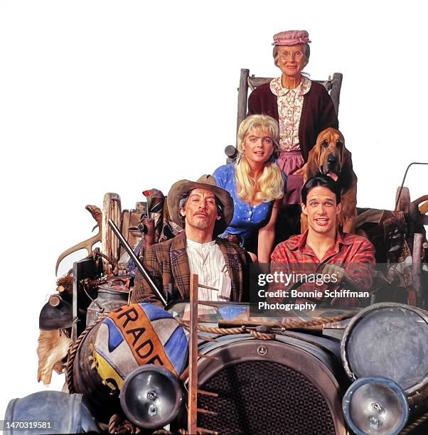 The Beverly Hillbillies feature film cast Cloris Leachman, Jim Varney, Diedrich Bader, Erika Eleniak and bloodhound Duke pose in their packed jalopy...