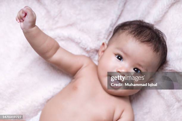 portrait of a baby with soft blanket color background - indonesian girl stock pictures, royalty-free photos & images