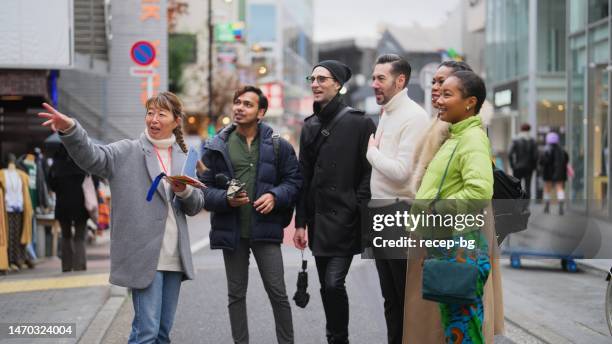 東京の地元のツアーガイドと一緒に街を探索する観光客の友人の多民族グループ - ツアーガイド　日本 ストックフォトと画像