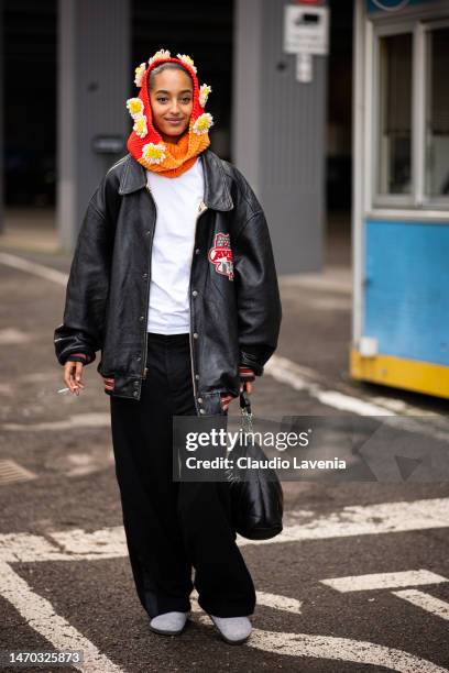 Mona Tougaard wears a white t-shirt, black trousers, black leather jacket and decorated knitted balaclava, outside Salvatore Ferragamo, during the...
