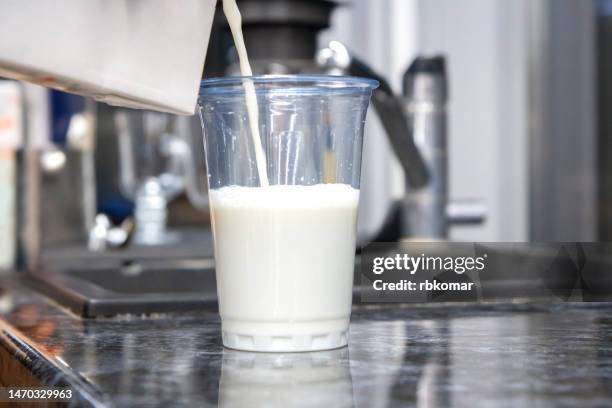 oat milk - pouring a drink into a transparent plastic cup - room service stockfoto's en -beelden