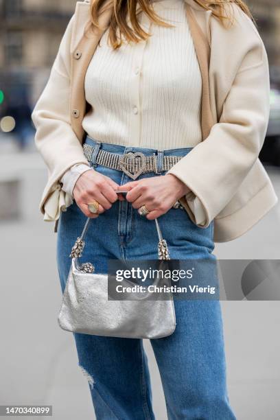 Maria Rosaria Rizzo wears pink bucket hat, creme white jacket, silver bag, denim jeans, creme white jumper, belt with rhinestones, pink heeled...