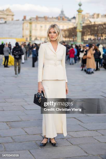 Elsa Hosk wears black bag, creme white blazer, skirt with slits outside Dior during Paris Fashion Week - Womenswear Fall Winter 2023 2024 : Day Two...