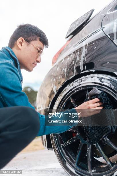 auto detailing - man cleaning wheels - car wash - auto mieten stock pictures, royalty-free photos & images