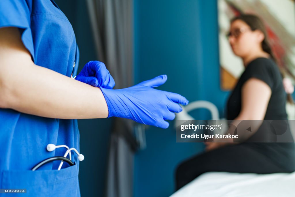 Healthcare worker wearing blue protective gloves