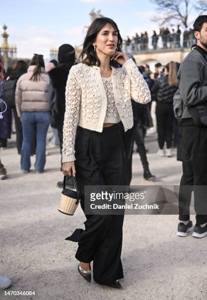 Jeanne Damas is seen wearing a Dior knit jacket and top and black pants with a straw bag outside the Dior show during Paris Fashion Week F/W 2023 on...
