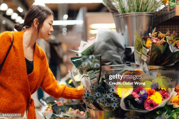 young asian woman buying fresh flowers from the store - floral stock pictures, royalty-free photos & images