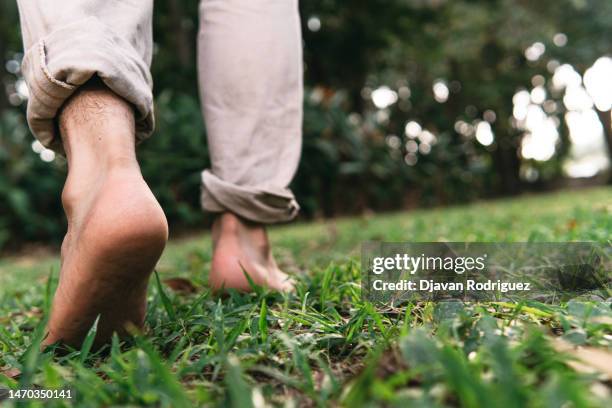 bare feet of a man walking on the grass - bare feet stock-fotos und bilder