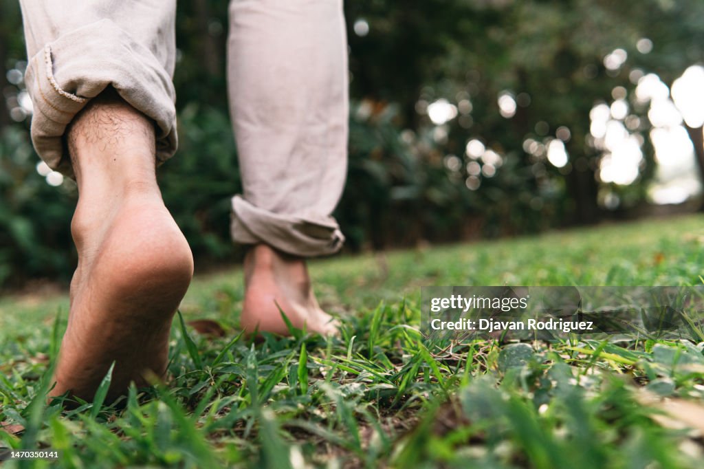 Bare feet of a man walking on the grass