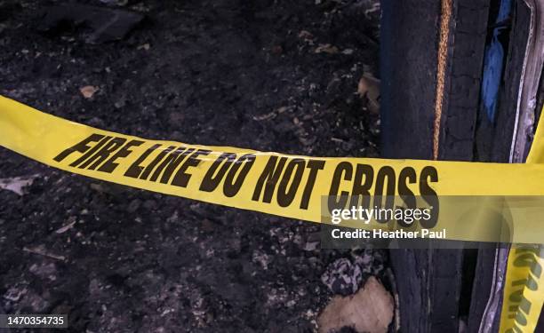 police investigation tape across the door at a suspected arson fire scene - investigación criminal fotografías e imágenes de stock