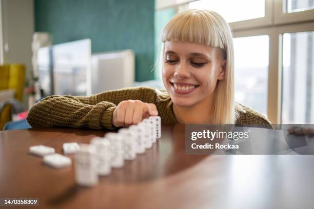 woman pushing domino pieces - domino effect stock pictures, royalty-free photos & images