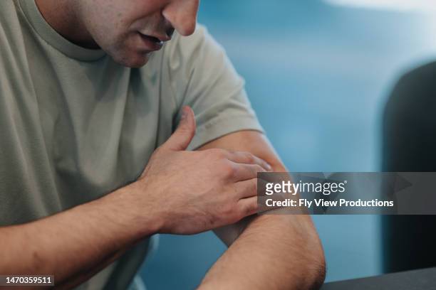痛みを和らげるために大麻局所軟膏を塗る認識できない男性 - arm pain ストックフォトと画像