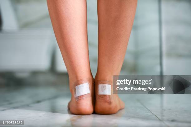 low section of woman with bandages on feet - blister stock pictures, royalty-free photos & images