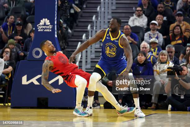 Draymond Green of the Golden State Warriors is guarded by Damian Lillard of the Portland Trail Blazers at Chase Center on February 28, 2023 in San...