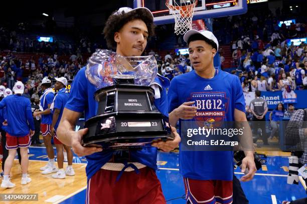 Jalen Wilson carries the Big 12 conference trophy with teammate Kevin McCullar Jr. #15 of the Kansas Jayhawks after their 67-63 win over Texas Tech...