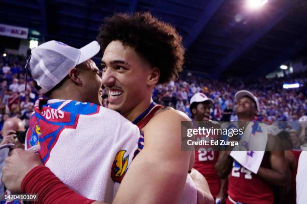 Jalen Wilson hugs Kevin McCullar Jr. #15 of the Kansas Jayhawks after their 67-63 win over the Texas Tech Red Raiders at Allen Fieldhouse on February...